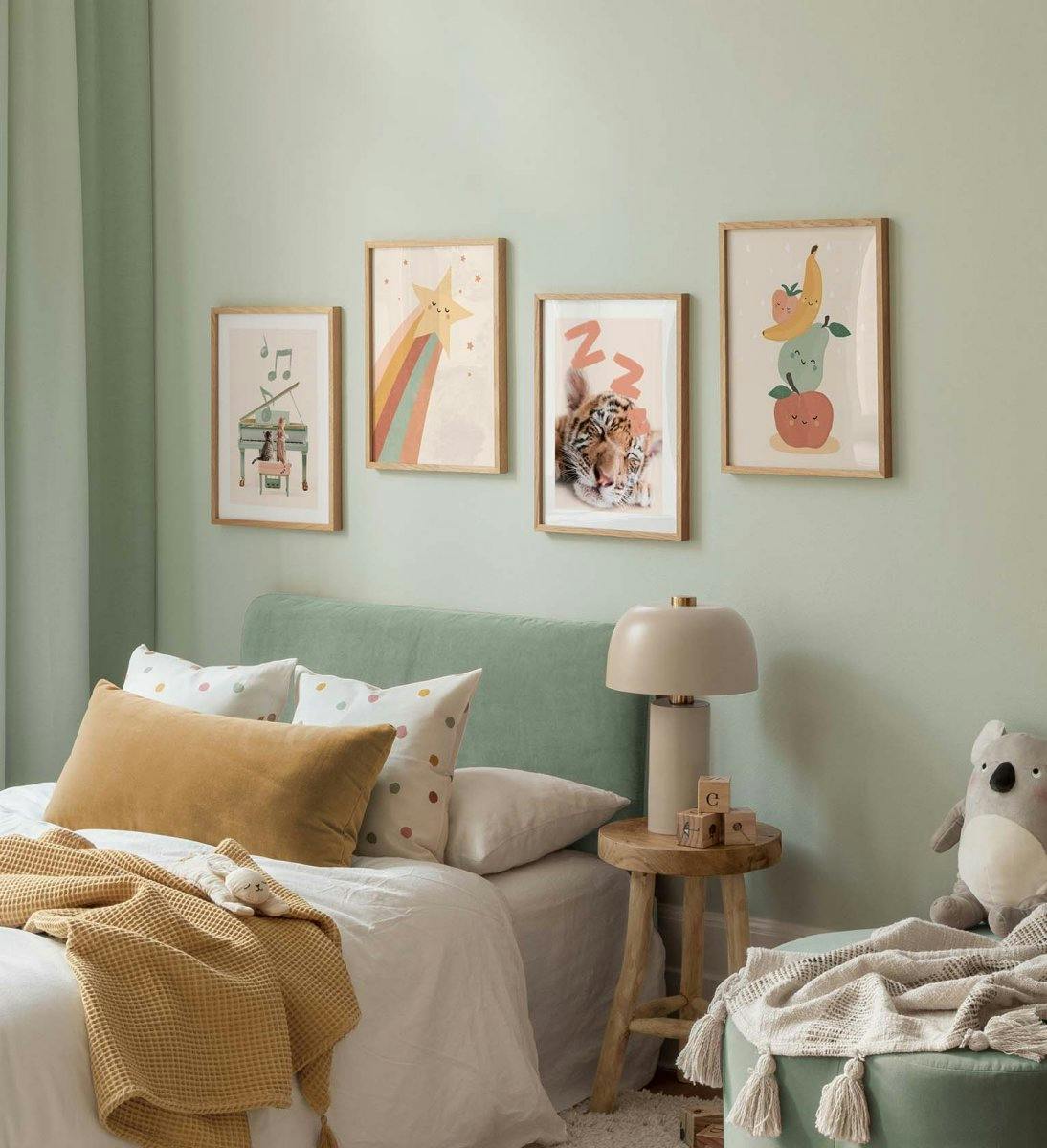 Galeriewand für das Kinderzimmer mit fröhlichen Drucken von Obstillustrationen und Tierplakaten in Pastellfarben mit Eichenrahme
