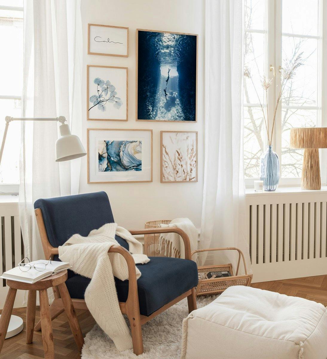 Pared de galería azul y beige con temática de naturaleza y mar con marcos de roble para sala de estar