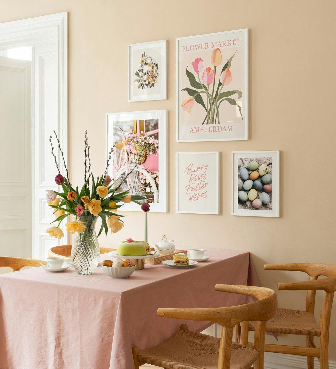Húsvéti galériafal pasztellszínű illusztrációkkal és fényképekkel, valamint fehér fakerettel az étkezőbe