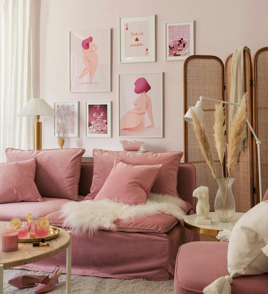 Girl power ihlette galériafal rózsaszín női formákból, illusztrációkból és fényképekből, fehér fa keretekkel a nappaliban