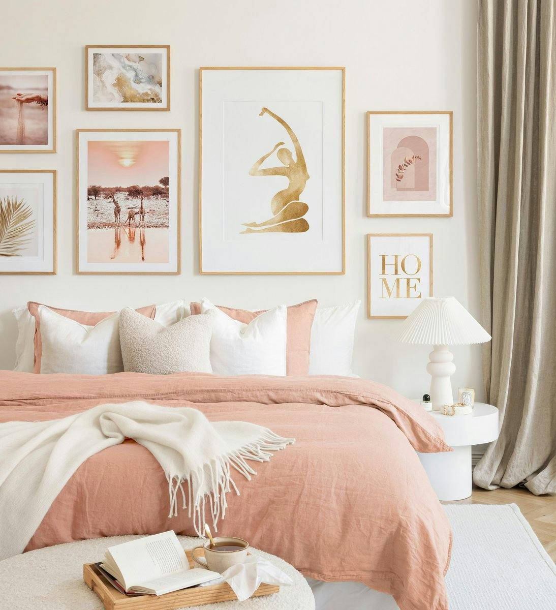 オーク材のフレームに柔らかなピンクやベージュの色彩を組み合わせたギャラリーウォールは、ベッドルームに調和のとれた雰囲気をもたらしてくれます。