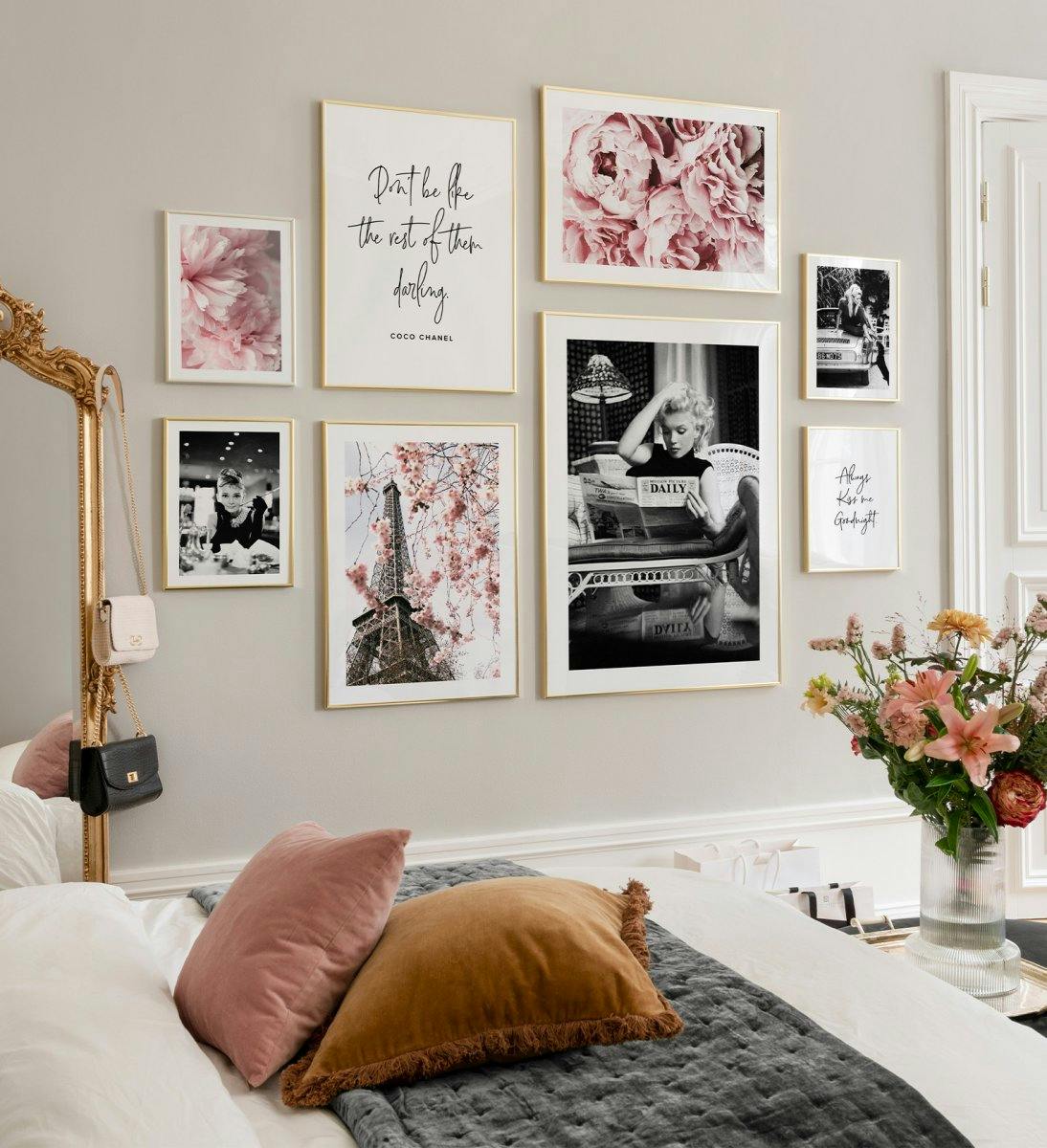Moderigtig billedvæg med lyserøde blomsterplakater, citatplakater og kendte plakater med gyldne rammer til stuen