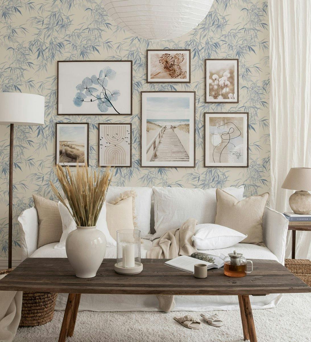 Nature gallery wall with photographs of beaches and botanical prints with dark wood frames for living room