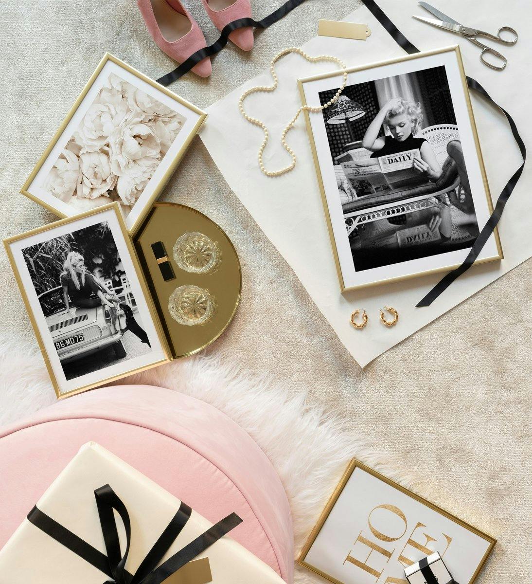 Iconic and monochrome wall art combined with beige and golden photographs and quotes with golden frames. The perfect gift for th