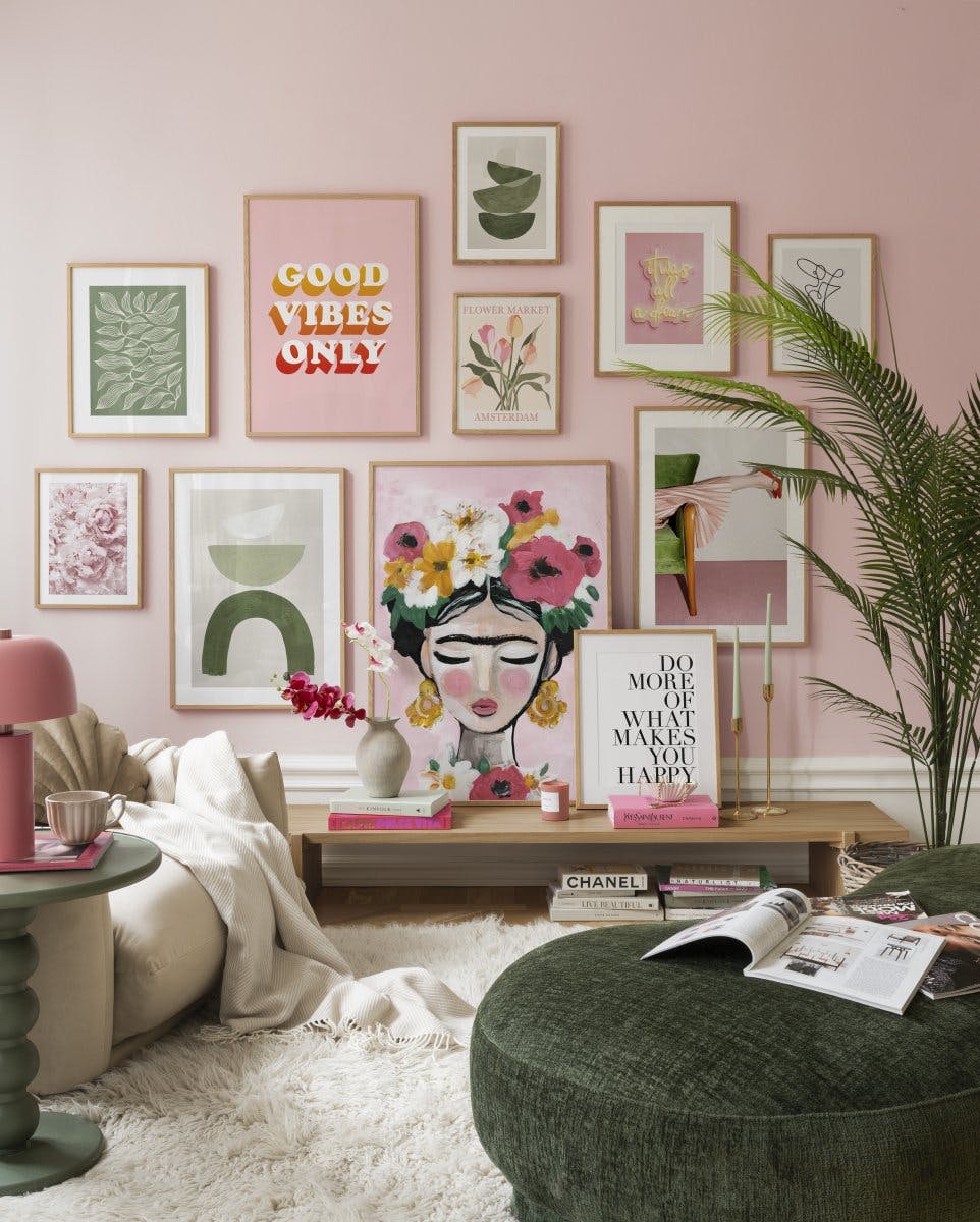 Galería de pared de tonos rosa y pop con marcos de roble para tu salón.