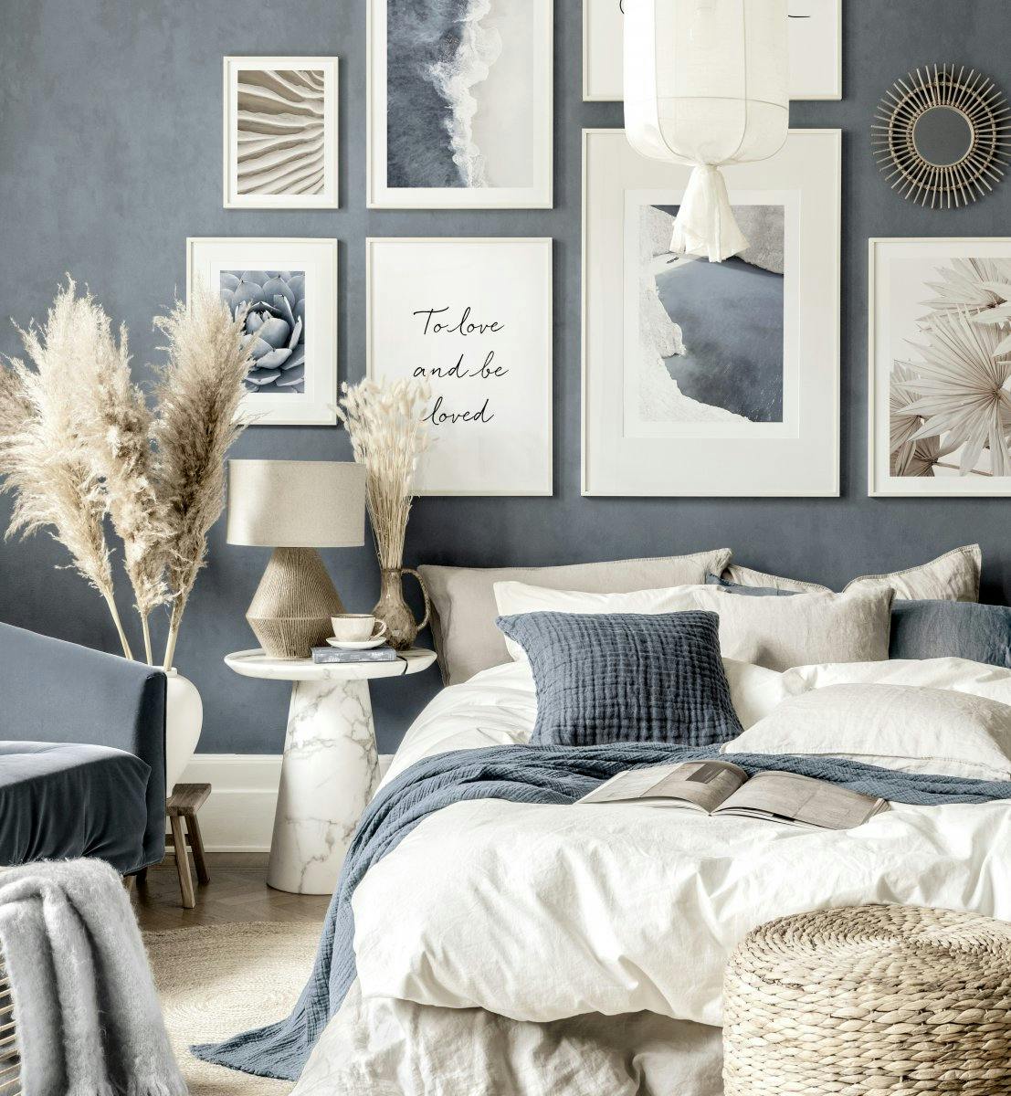 Modrobéžová stěna ložnice a bílé dřevěné rámy na obrazy