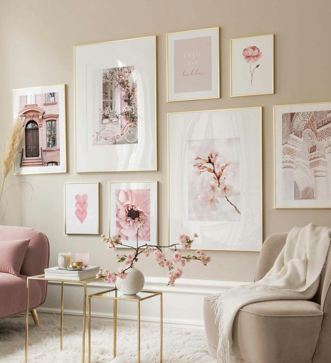 Vaaleanpunainen tauluseinä jossa on valokuvajulisteita olohuoneeseen tai makuuhuoneeseen.