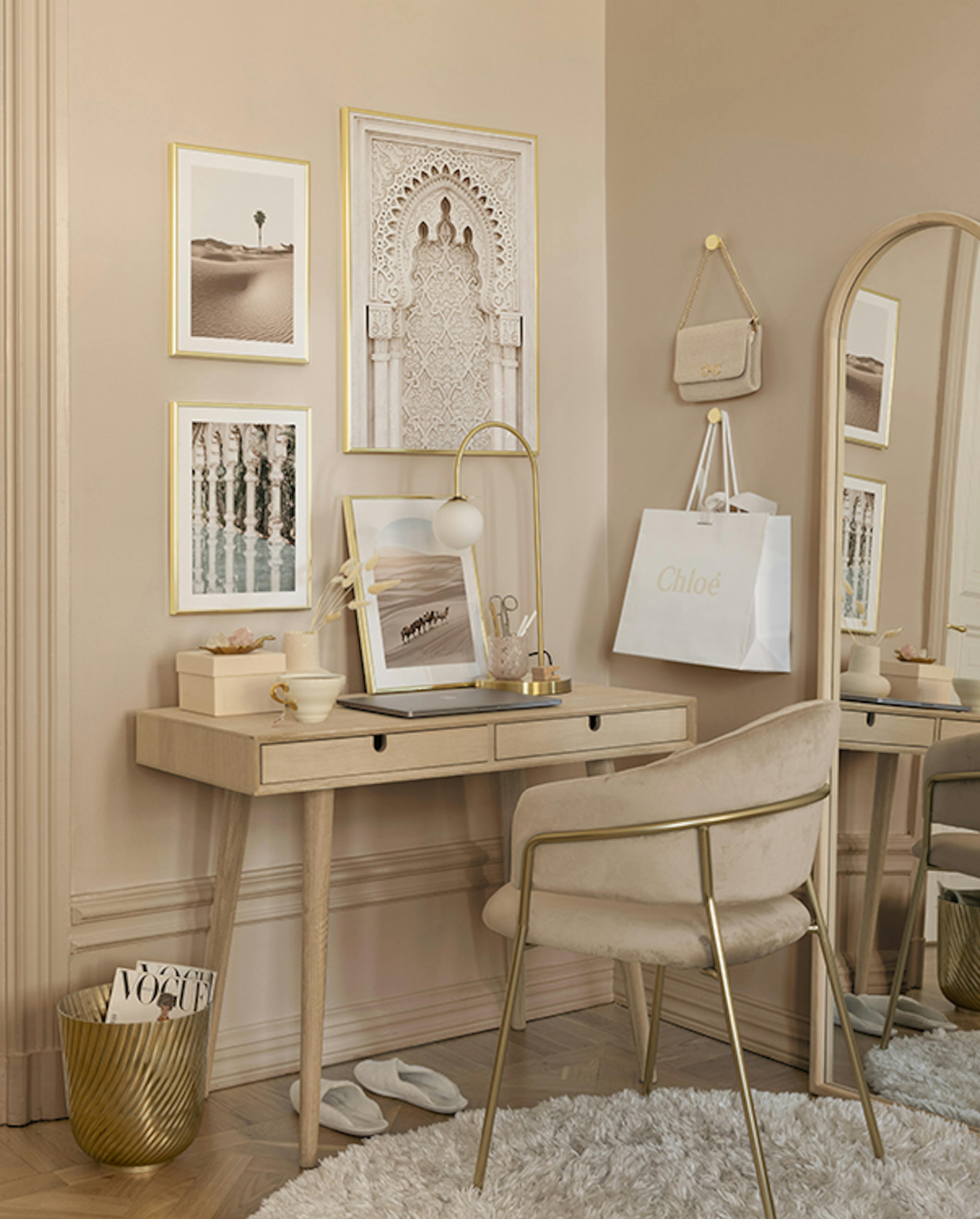 Historische Bilderwand kombiniert mit Naturpostern in einer beigen Farbpalette mit goldenen Bilderrahmen für das Home Office.
