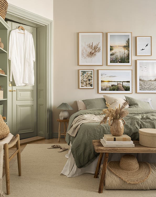 Galleria a parete nei toni del beige e del verde con poster della natura e cornici di quercia per la camera da letto