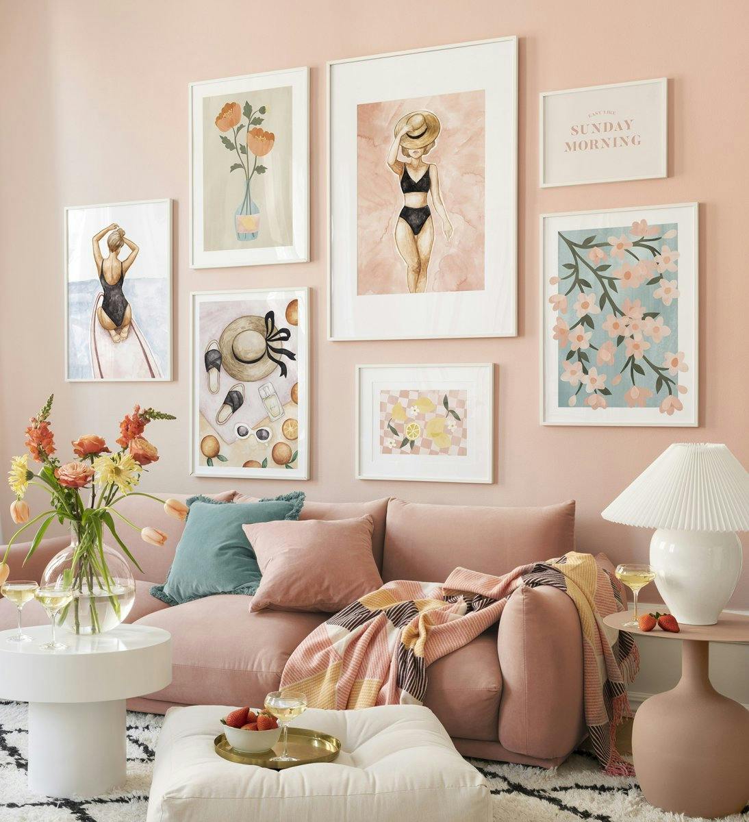 Barevná stěna galerie s květinovými tisky a ilustracemi v růžové barvě s bílými rámečky do obývacího pokoje