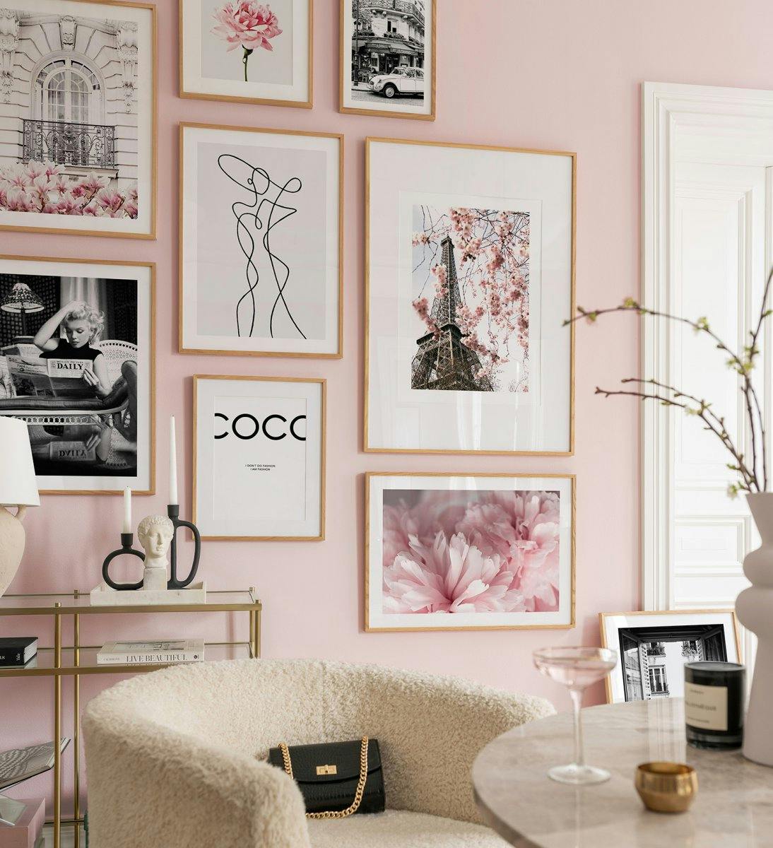 Parete gallery rosa e monocromatica con cornici in quercia per il soggiorno