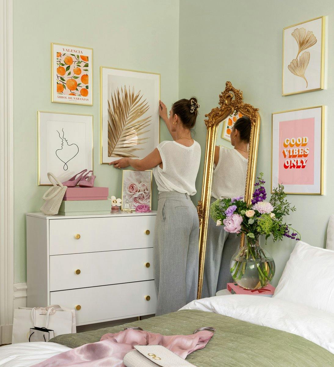Różowa, pomarańczowa i złota ściana galerii ze złotymi ramkami do sypialni