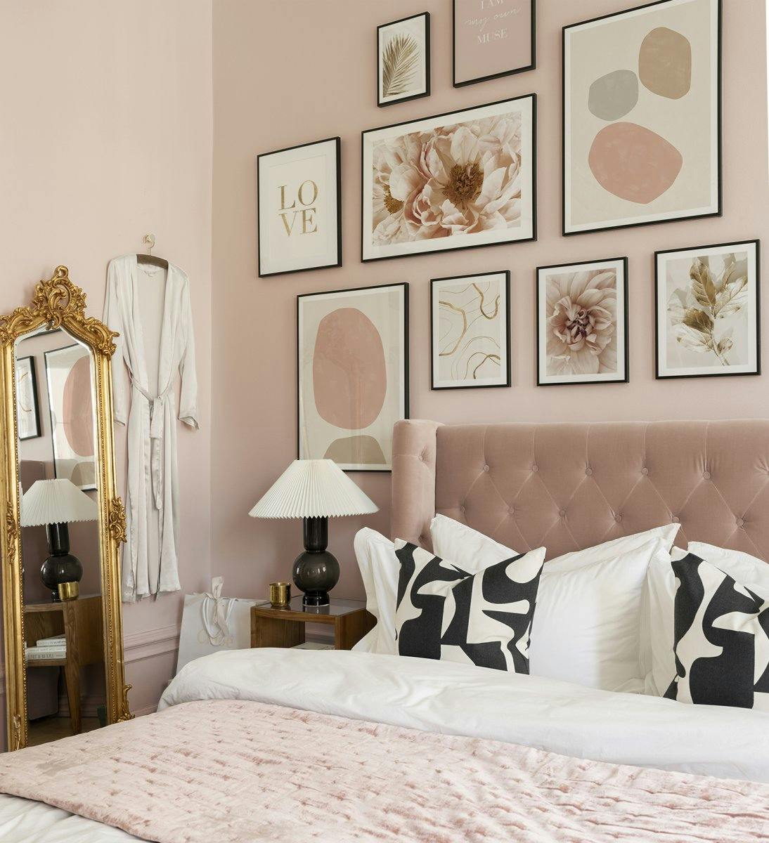 Perete calm de galerie roz și auriu cu rame metalice negre pentru dormitor